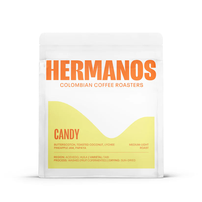 Front view of a white Hermanos Colombian Coffee Roasters bag of Candy medium-light roast coffee, featuring a yellow lower label.