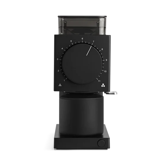 Front view of a matte black Fellow Ode Gen 2 coffee grinder featuring a large central dial with numerical settings and a transparent hopper.
